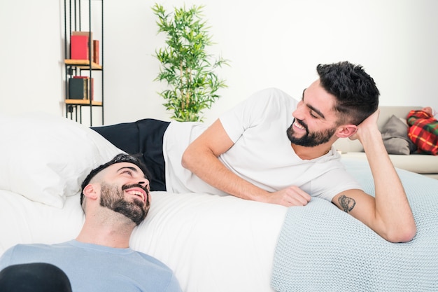 Relaxed handsome young gay couple looking at each other