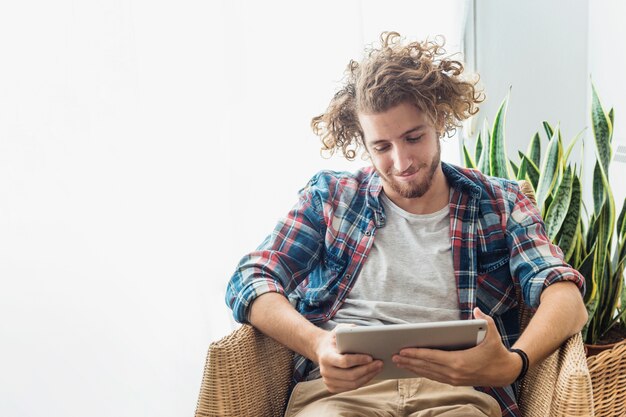 Relaxed man looking at tablet