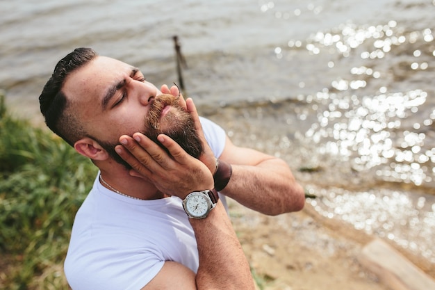 Relaxed man touching his beard