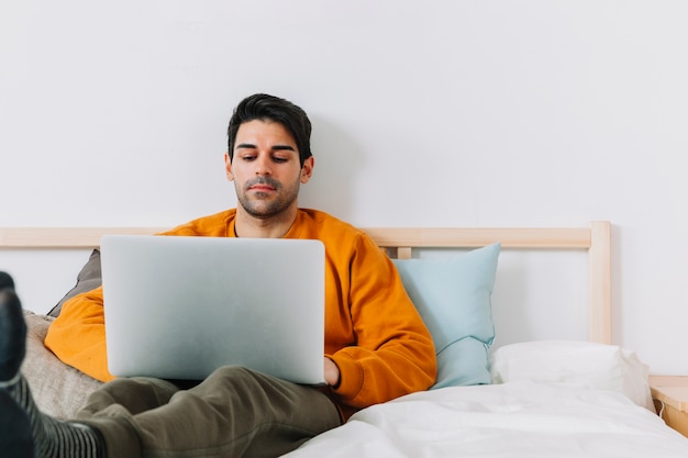 편안한 남자 침대에서 노트북을 사용