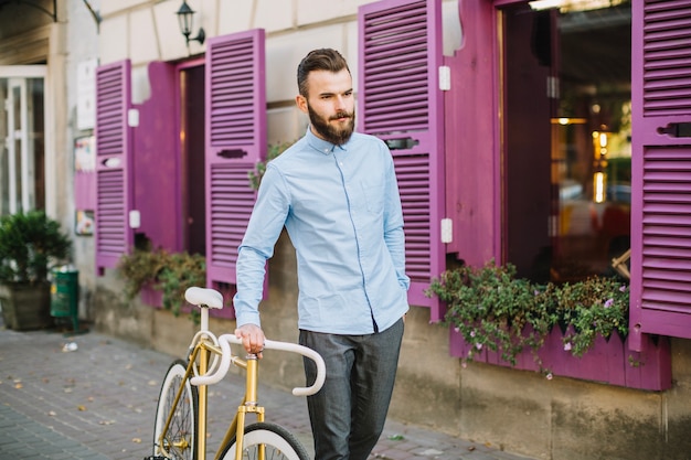 Relaxed man walking with bicycle