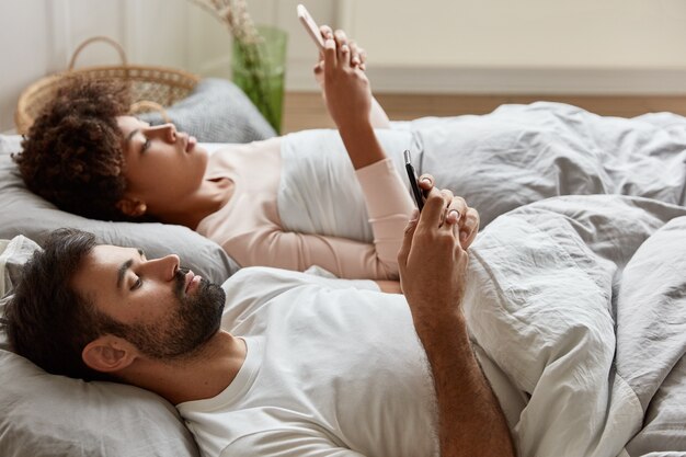 Relaxed serious couple share photos from telephone