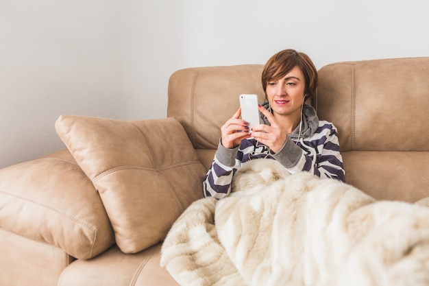 Free photo relaxed woman listening to music on the couch