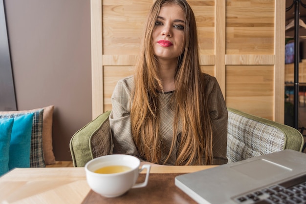 Relaxed woman with laptop and cup of tea