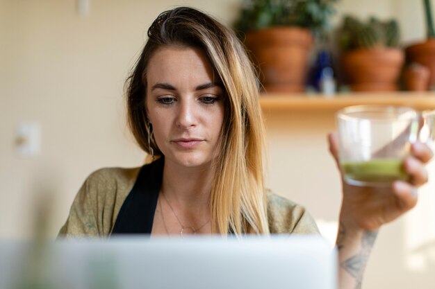 Расслабленная женщина работает из дома на своем ноутбуке