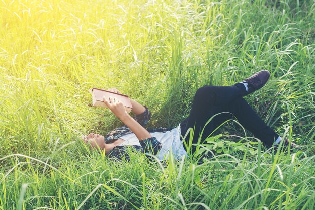 Расслабление молодой человек, читающий на открытом воздухе
