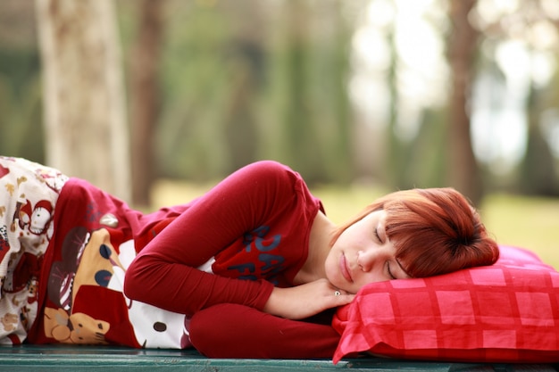 Free photo relaxed young woman sleeping outdoors