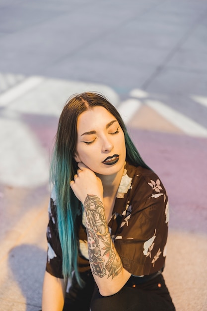 Free photo relaxed young woman with tattoo on her hand