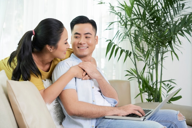 Relaxing couple in love on couch with laptop