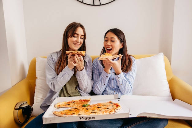 Расслабляющие женщины, имеющие пиццу