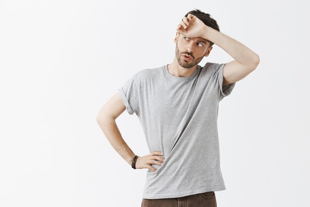 Relieved handsome guy posing against the white wall