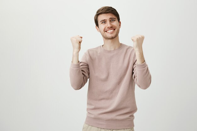 Relieved happy man rejoicing over good news, fist pump triumphing