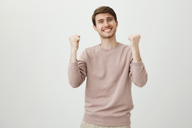 Бесплатное фото Облегченный счастливый человек радуется хорошим новостям, торжествует кулак