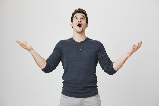 Relieved man thanking god, looking up sky grateful