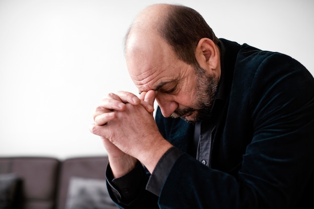 Religious man praying indoors