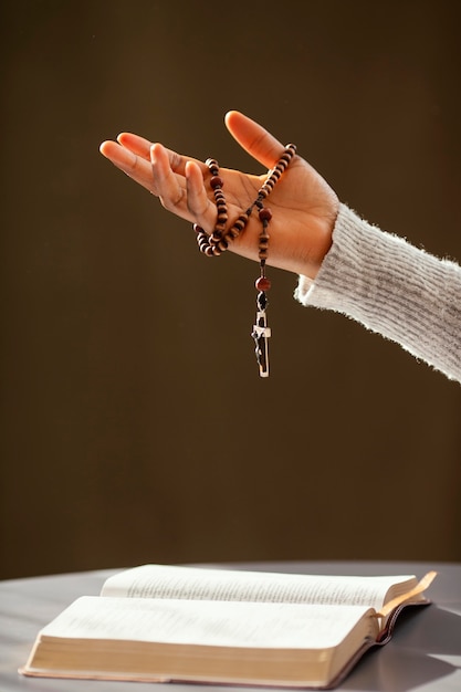 Religious woman praying with rosary beads