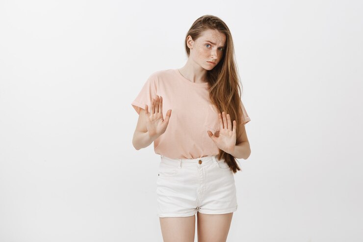 Free Photo reluctant teenage girl posing against the white wall