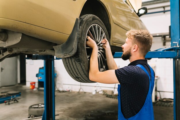 Repairman fixing tyre in shop