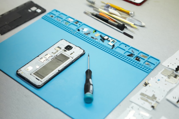 Repairman's workplace with cell phone and special tools on desk