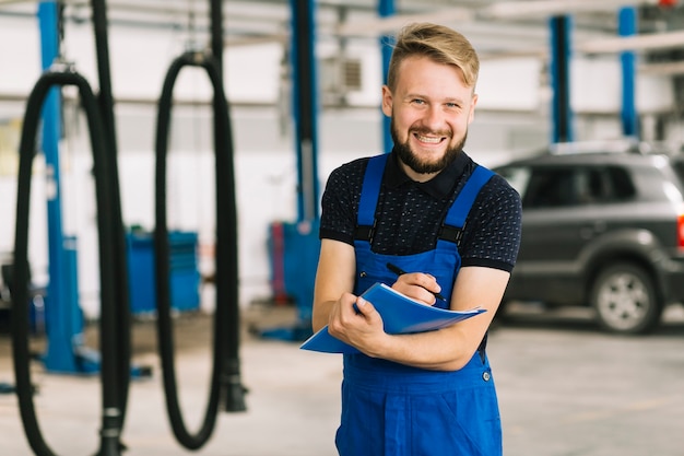 Repairman with folder smiling at workshop