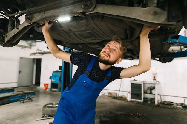 Repairmen inspecting car bottom