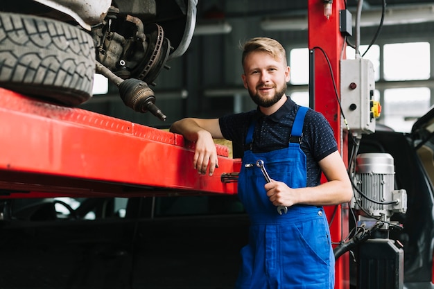 Free photo repairmen leaning on car elevator