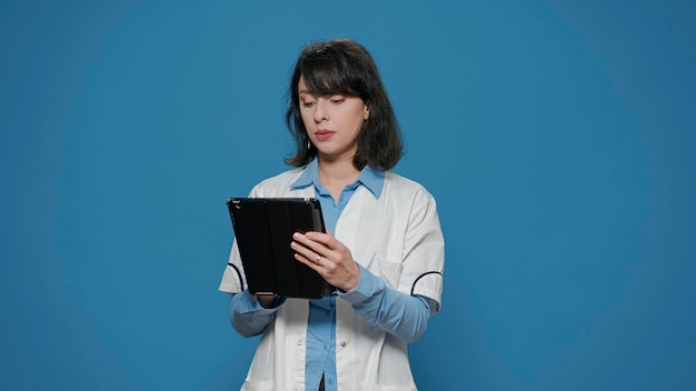 Research scientist using digital tablet to browse internet and find biochemistry discovery. Female chemist working with device to create pharmaceutical cure, microbiology experiment.