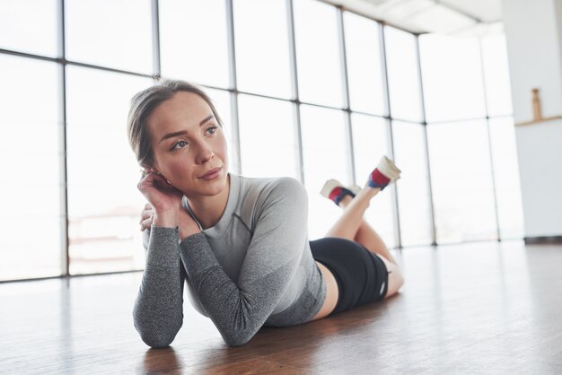 Rest time. Sportive young woman have fitness day in the gym at morning time