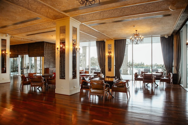 Restaurant hall with leather armchairs and french windows