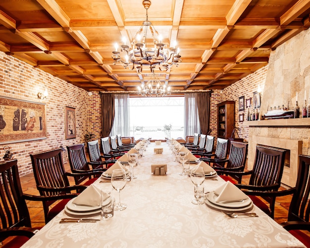 Restaurant table in the private room with fireplace, wooden ceilings and brick walls