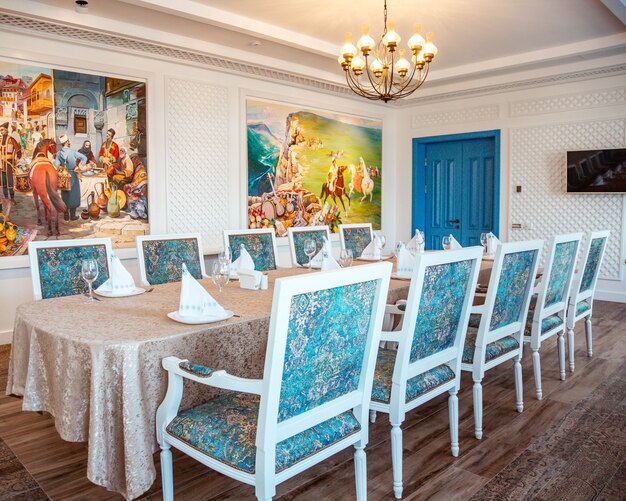 Restaurant table with classic white chairs and turquoise fabric