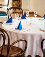 Foto gratuita tavolo da ristorante con tovaglia di pizzo bianco e tovaglioli blu