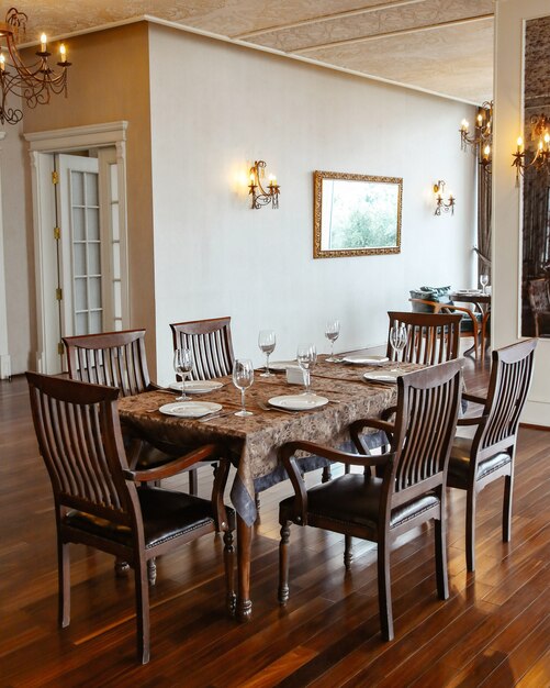 古典的なスタイルで装飾されたホールに置かれた木製の椅子とレストランのテーブル