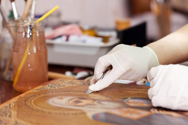 restorer cleaning ancient icon