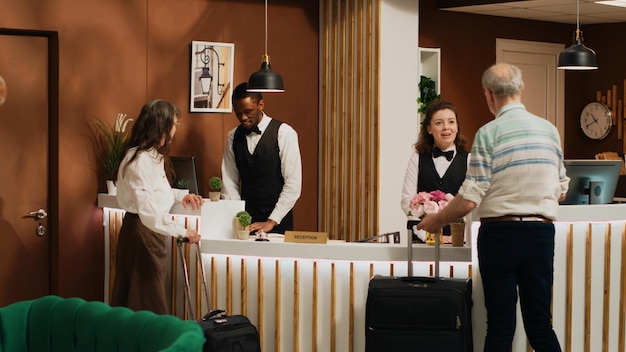 Free photo retired couple arrive at hotel reception