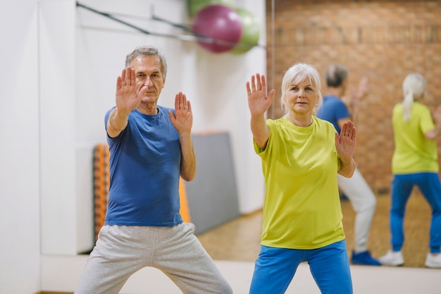 Пенсионеры пара делает упражнения