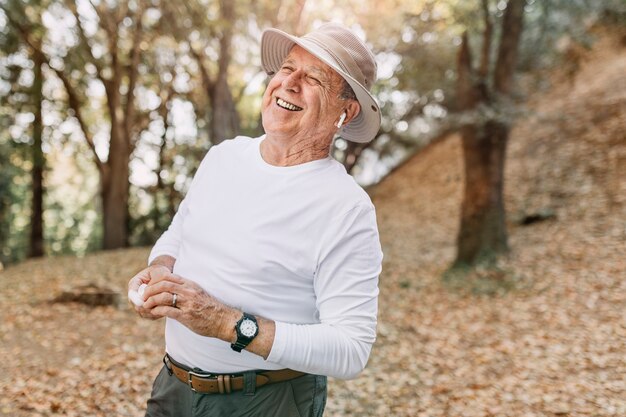 Retired man enjoying music in the middle of the forest