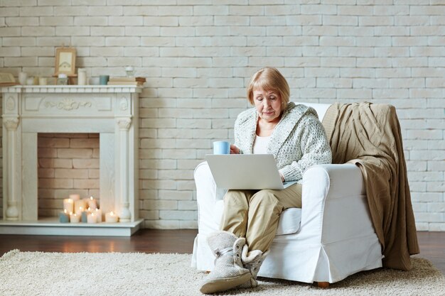 Retired woman ensconced herself in armchair