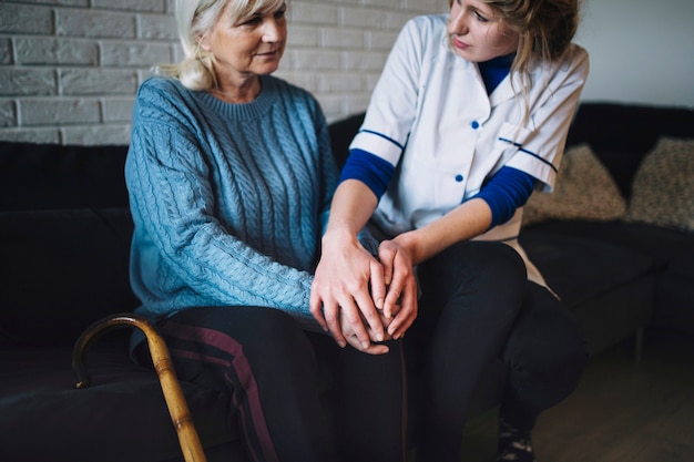 Retirement home concept with nurse taking care of woman