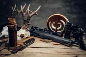 Free photo retro hunting ammunition of rifle and binoculars. delicious sausage and brown bread on a wooden table.