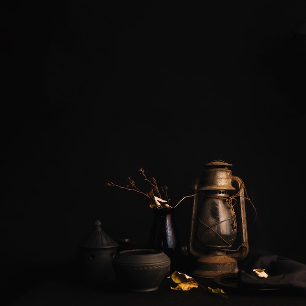 Бесплатное фото Ретро-лампа возле вазы и горшков