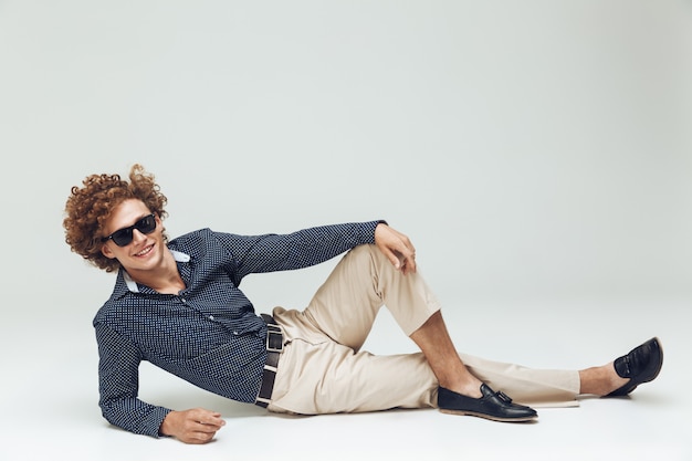 Retro man dressed in shirt lies on floor and posing