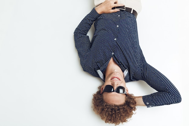 Retro man dressed in shirt lies on floor and posing