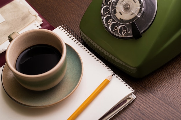 Retro phone, notebook and coffee cup