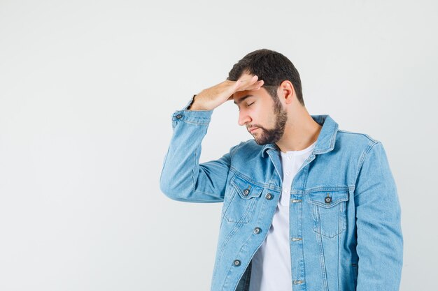 Retro-style man in jacket,t-shirt holding hand on his head and looking tired . free space for your text