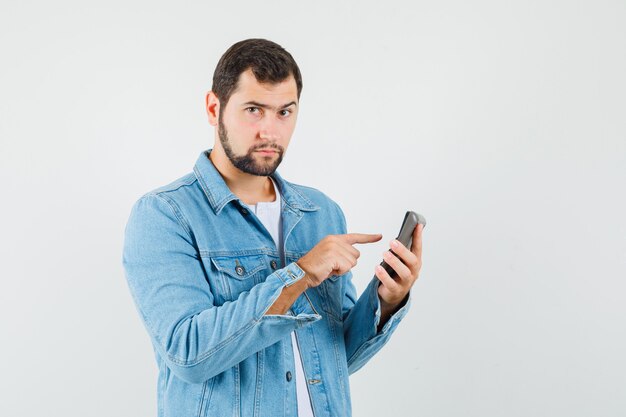 Retro-style man in jacket,t-shirt preparing for calling someone and looking ready , front view.