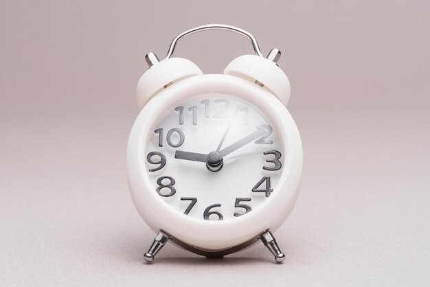 Retro styled alarm clock on plain background