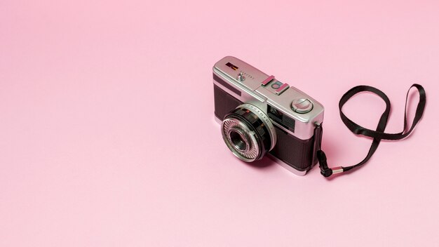 ピンクの背景にレトロなスタイルのカメラ