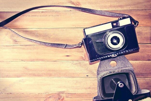 Retro vintage camera on wooden background.