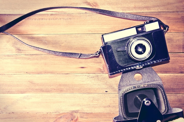 Retro vintage camera on wooden background.